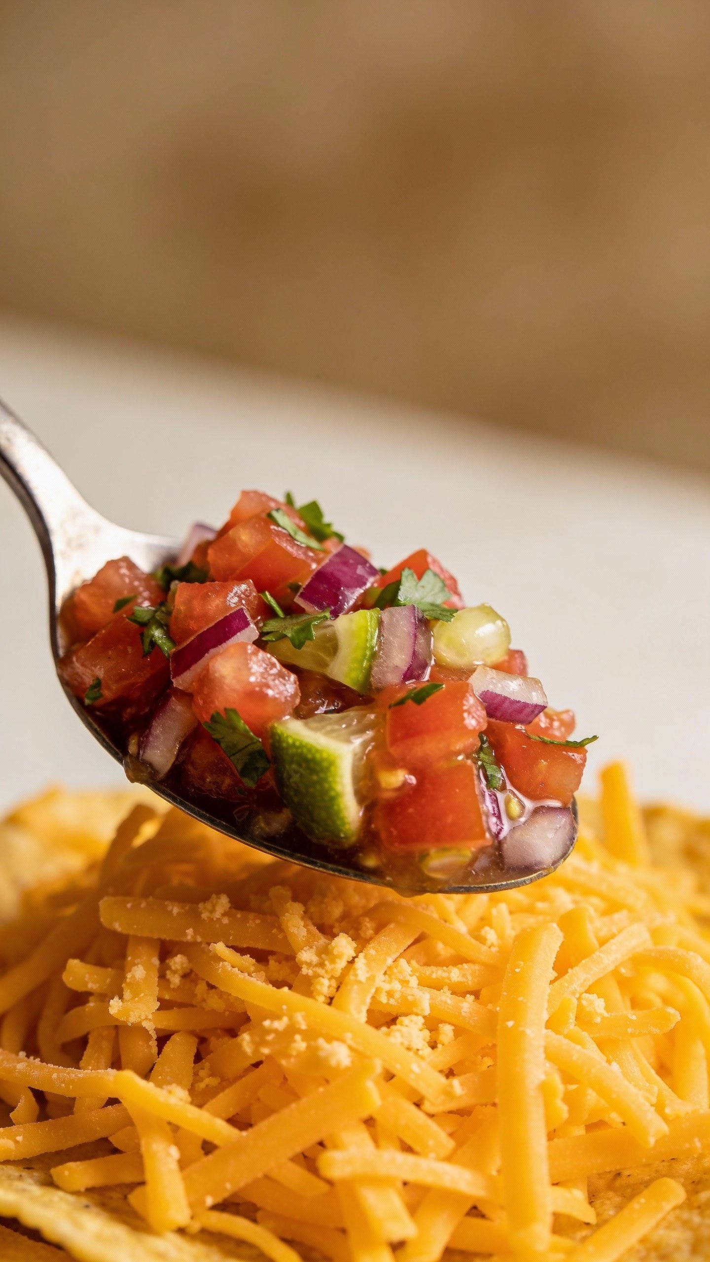 Spoonful of pico de gallo over shredded cheddar cheese