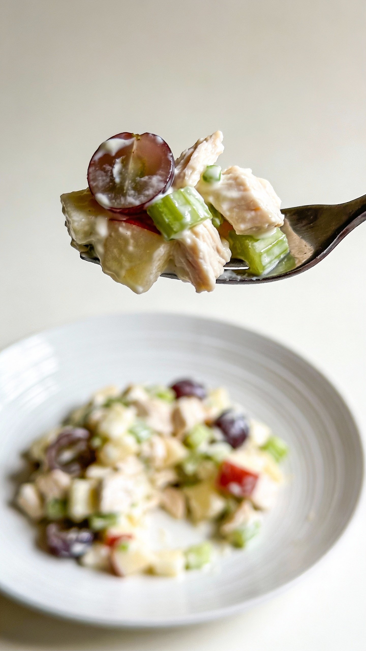 single forkful of chicken Waldorf salad over white plate