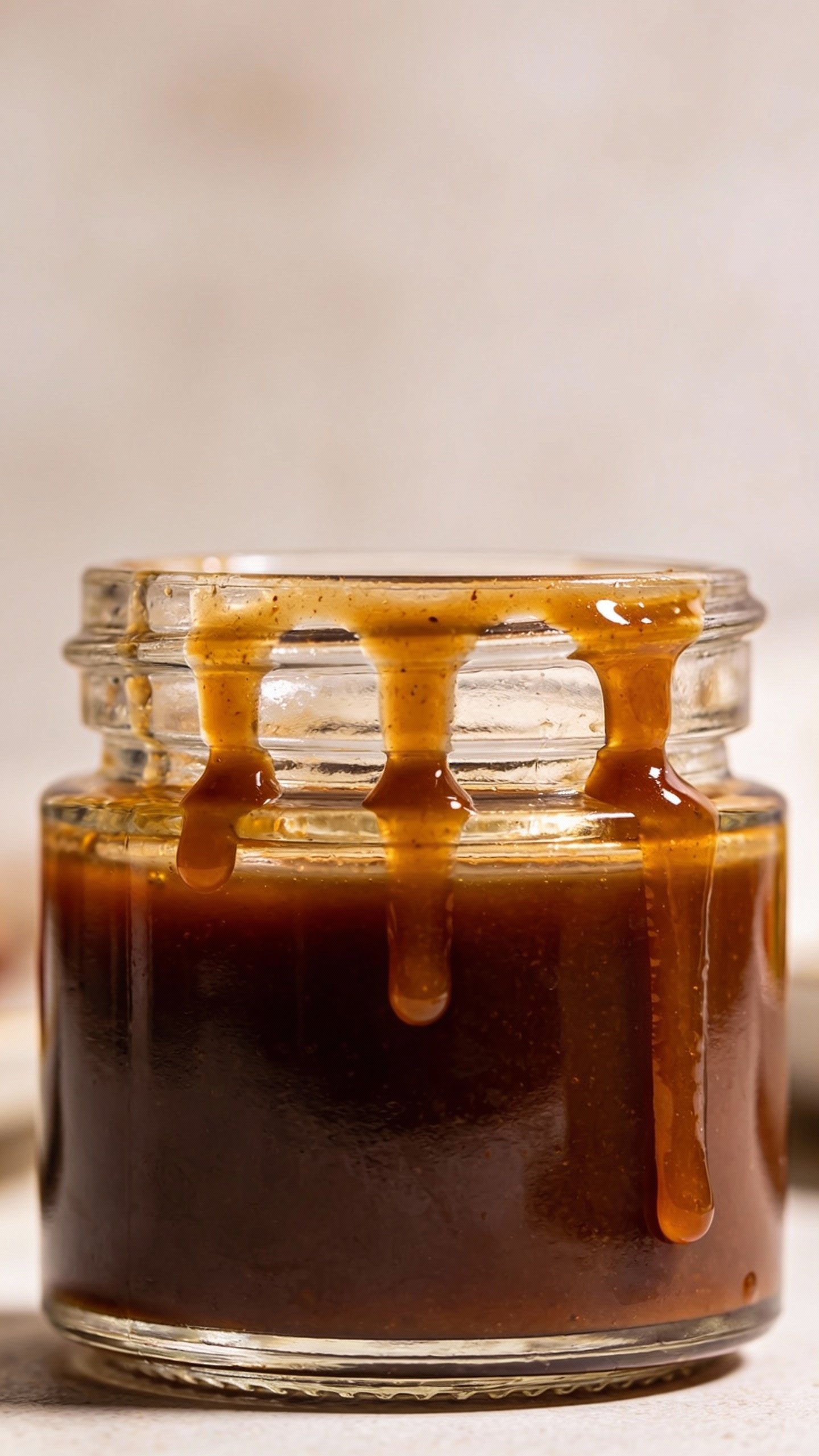 small glass jar of keto balsamic vinaigrette, drips on rim