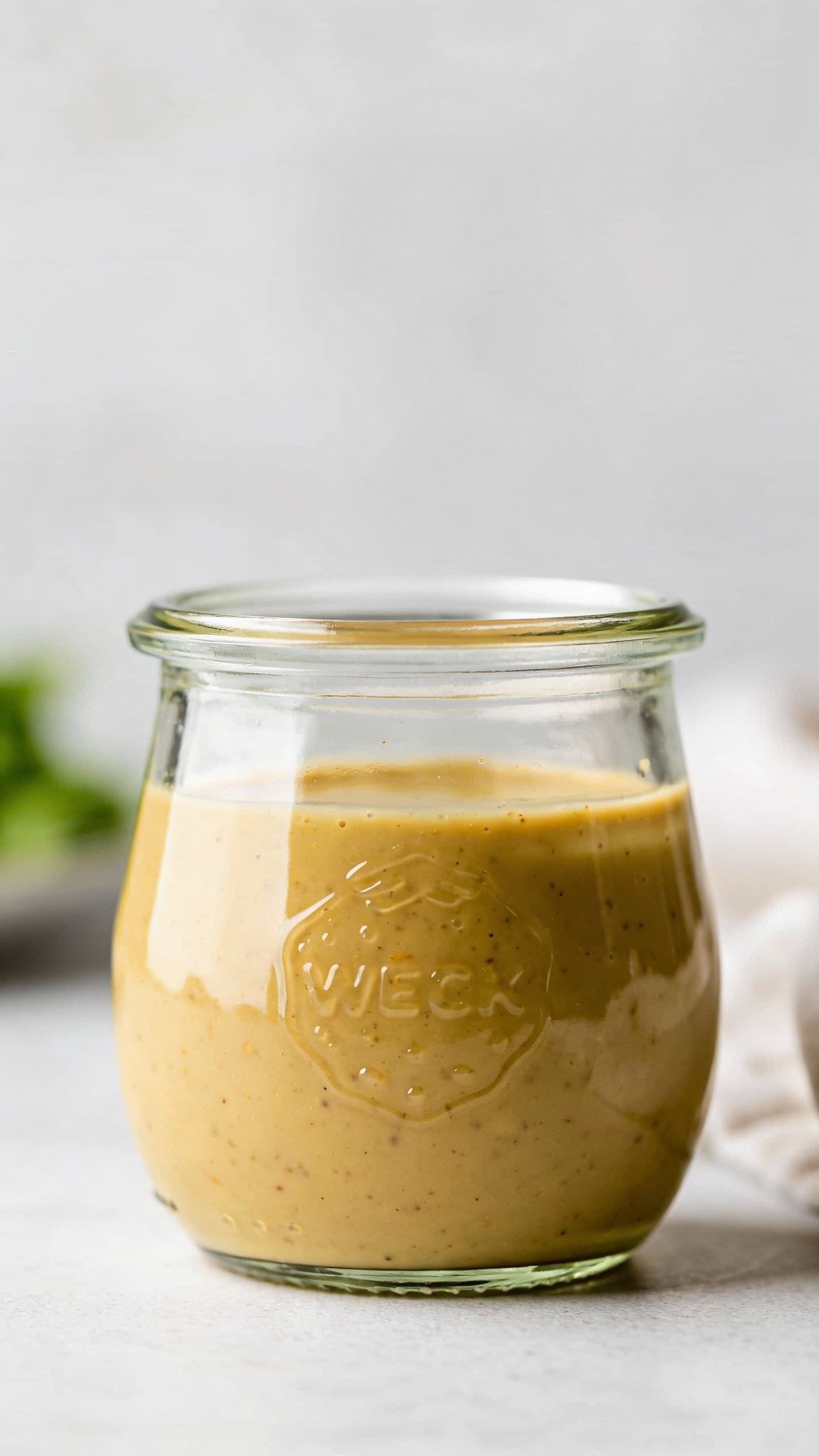 glass jar of keto Italian vinaigrette, emulsified, studio light