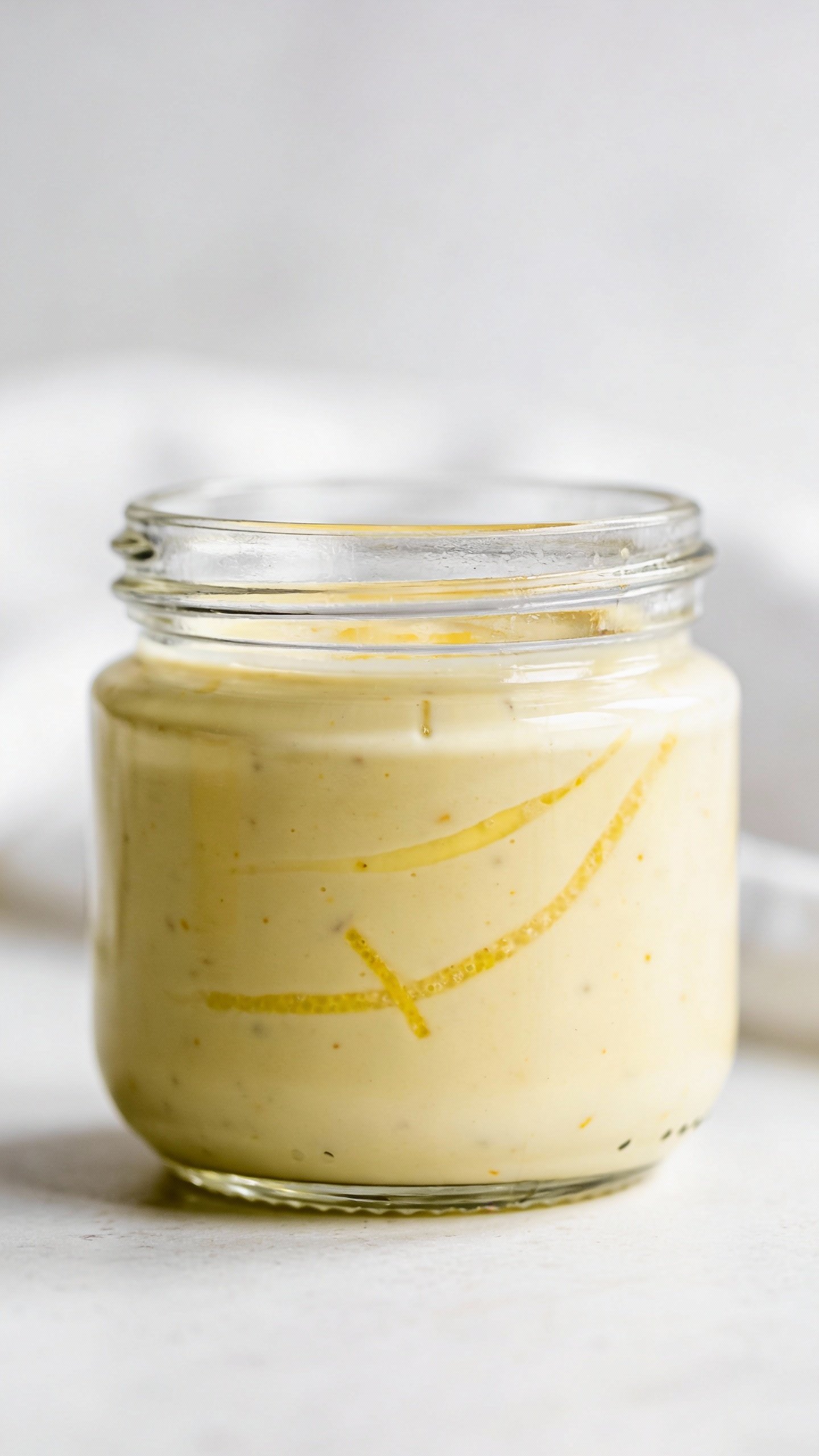 Small glass jar of keto lemon olive oil dressing
