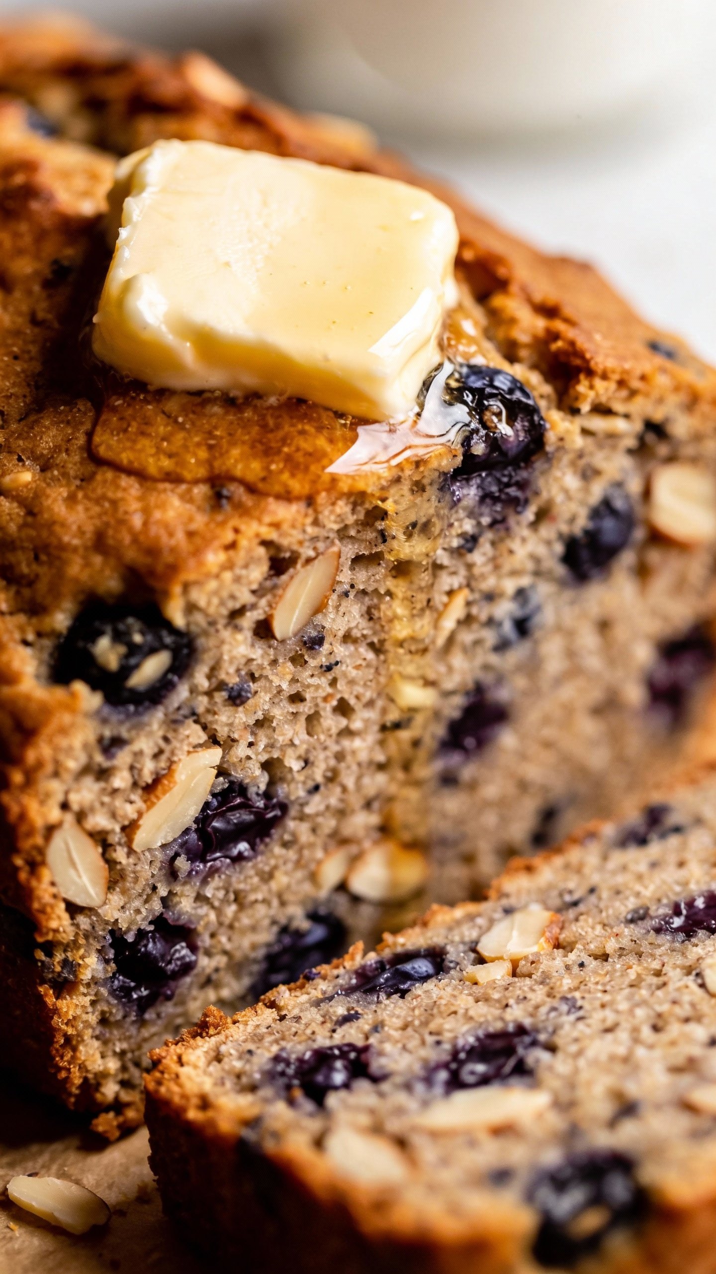 closeup slice of blueberry almond keto bread with butter