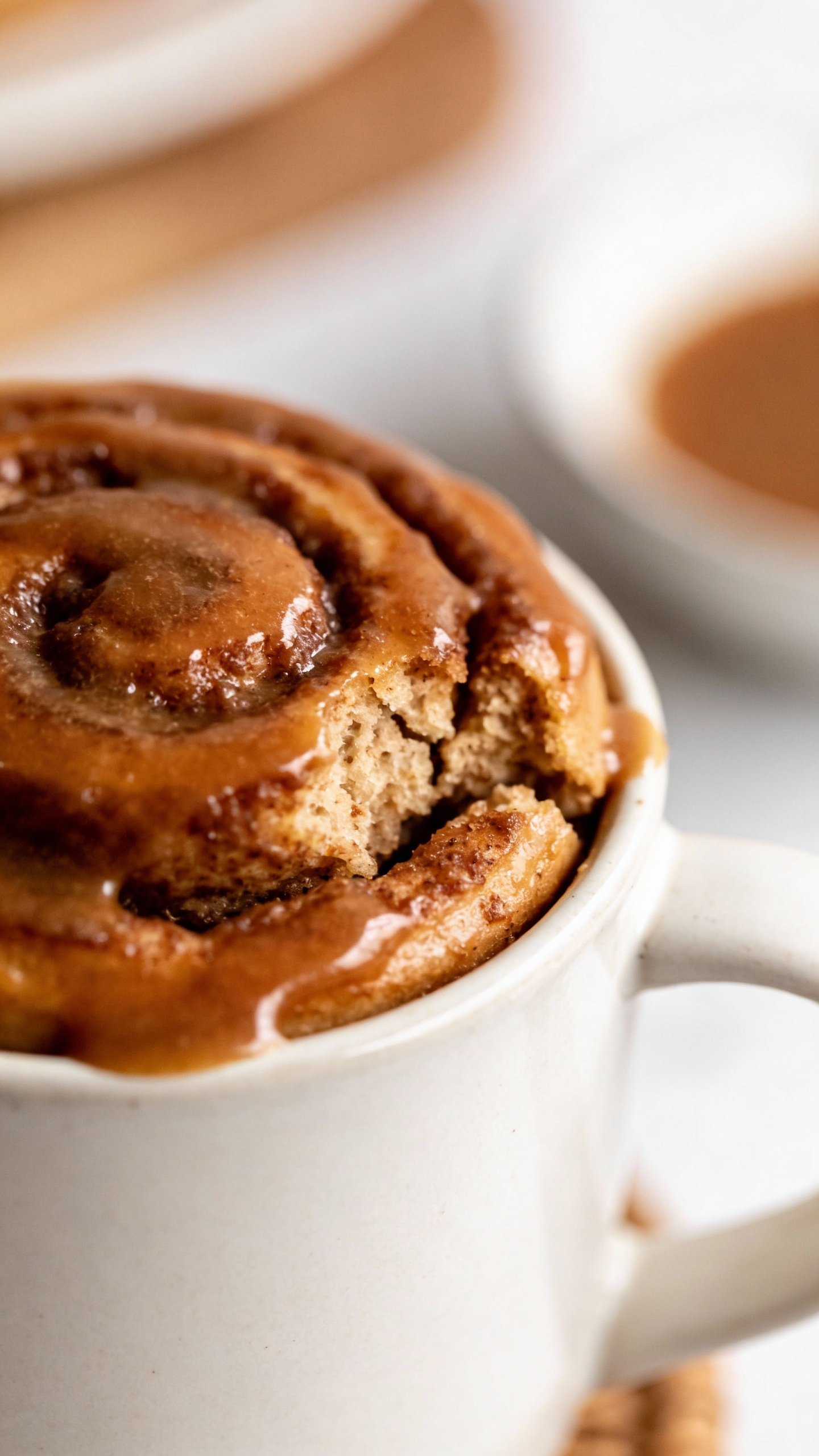 closeup keto cinnamon roll mug cake in white ceramic mug