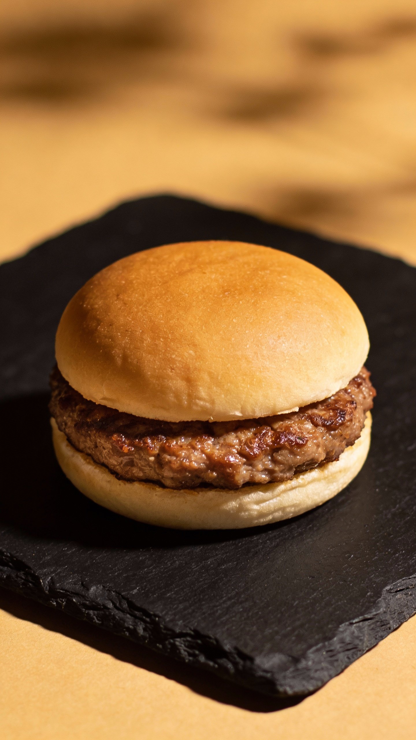 single sausage patty “bun” slider on black slate