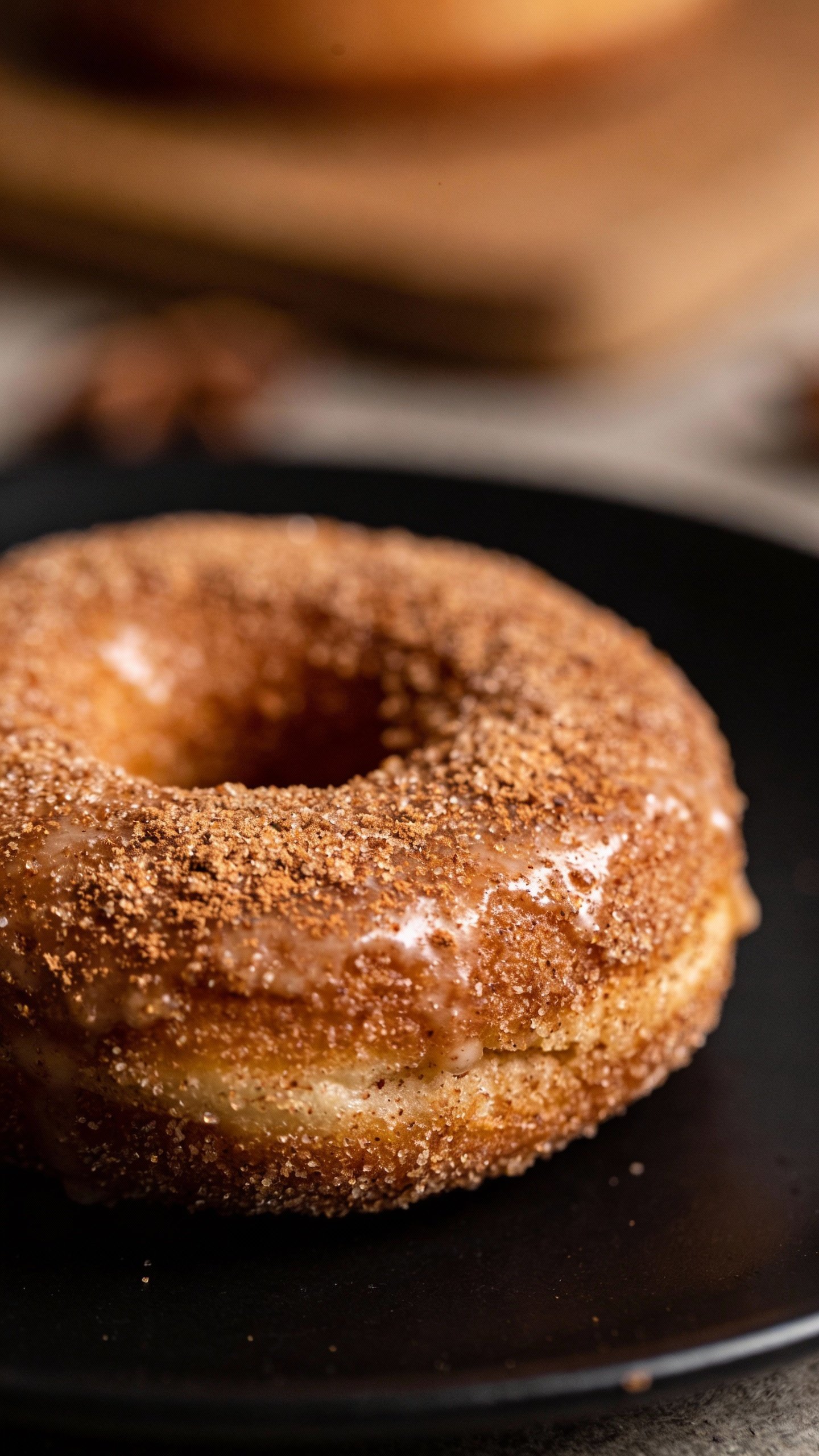closeup single keto cinnamon sugar donut on matte black plate