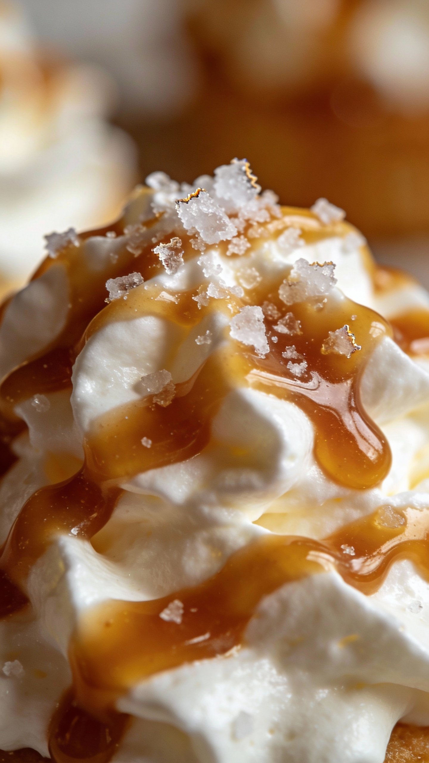 macro shot of caramel drizzle on whipped cream, sea salt flakes