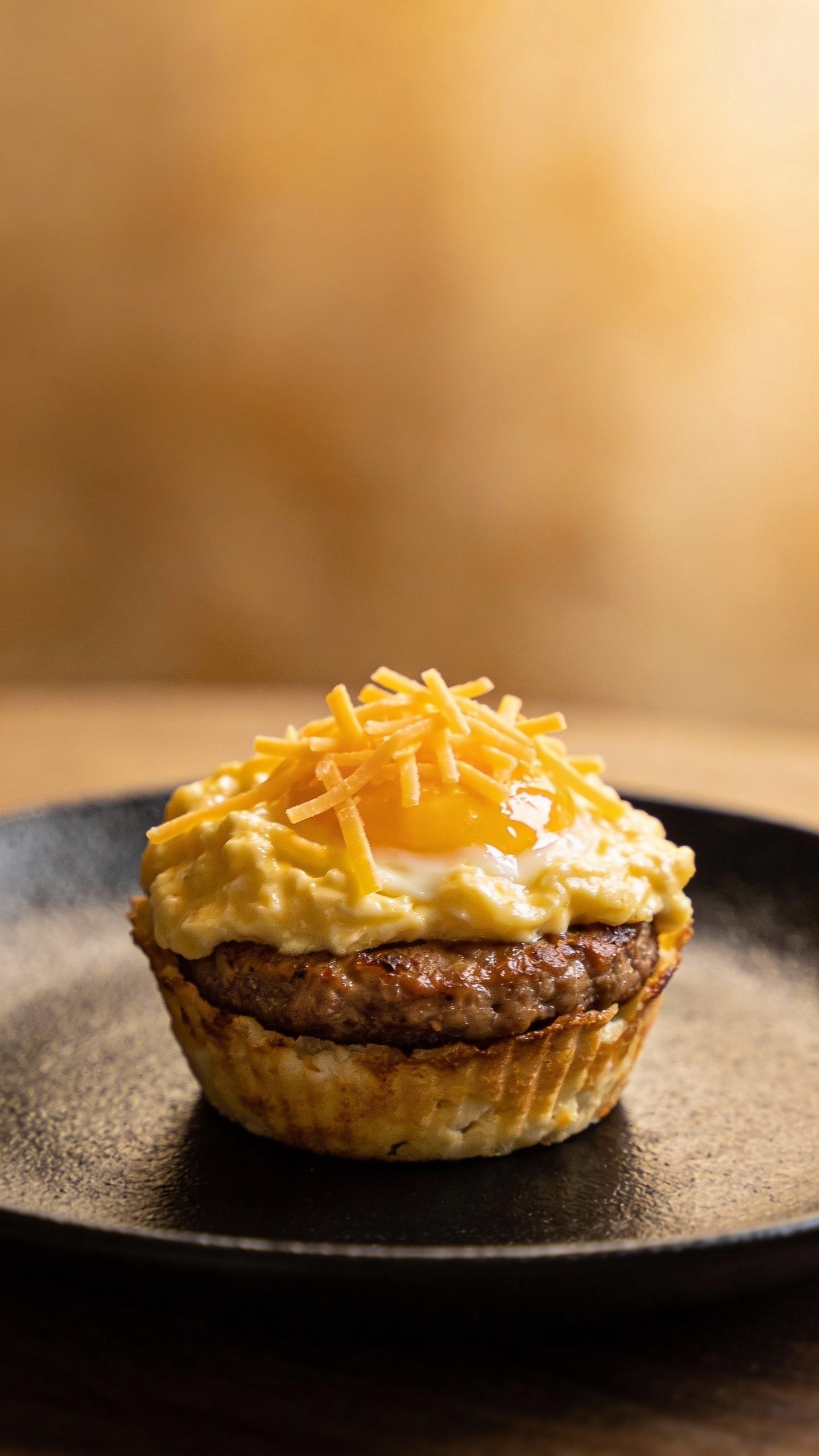 single keto sausage and egg breakfast cup on matte black plate