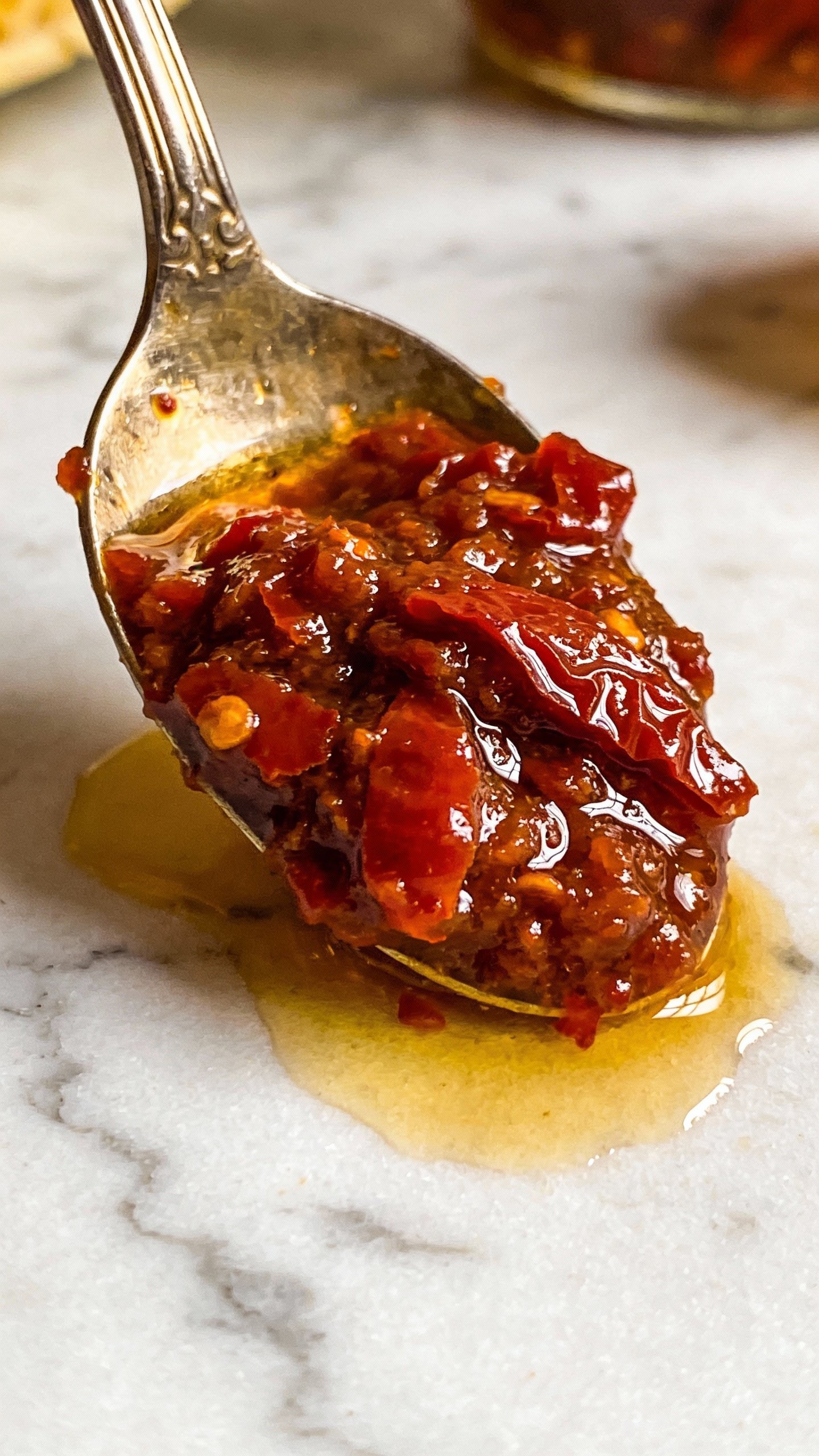 spoonful of glossy sun-dried tomato pesto over white marble