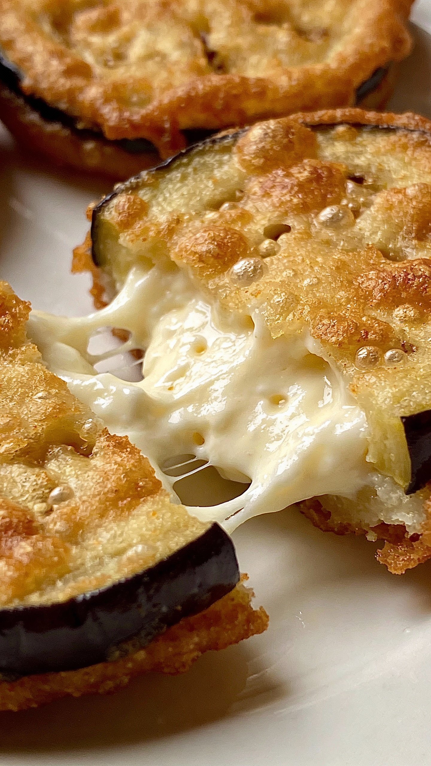 golden fried eggplant slice, ricotta filling exposed, macro shot