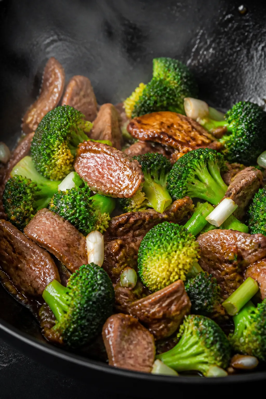 Close-up cooking process: Searing thin-sliced flank steak in a shimmering hot wok, browned edges wit
