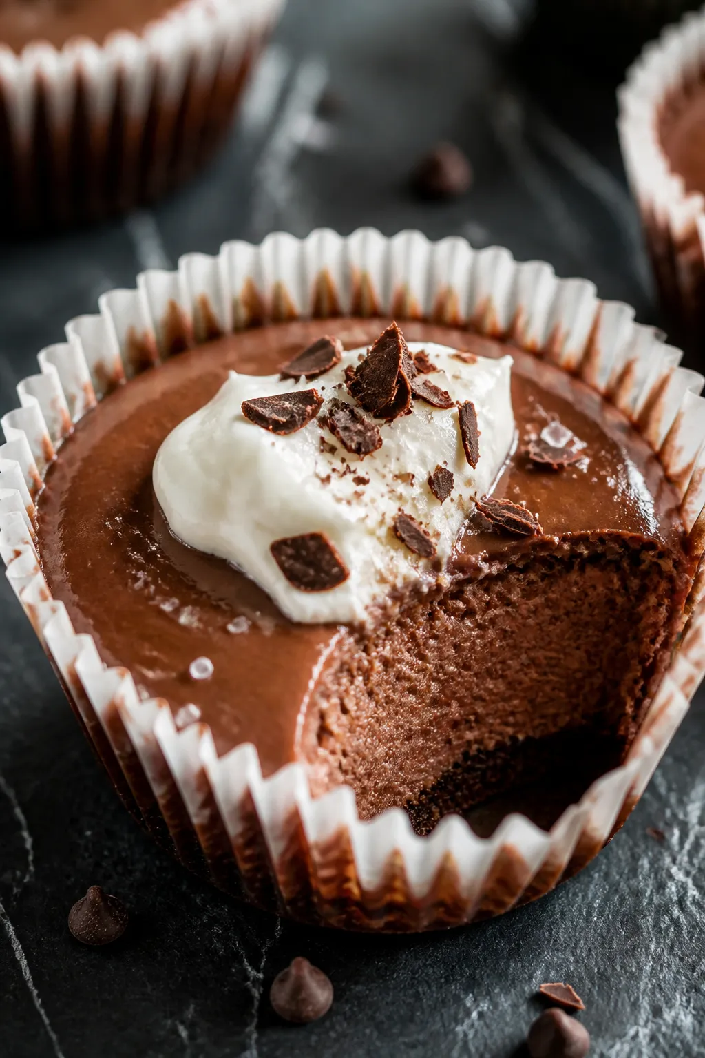 Close-up detail shot: A just-baked chocolate cheesecake cup still in its paper liner, edges set with