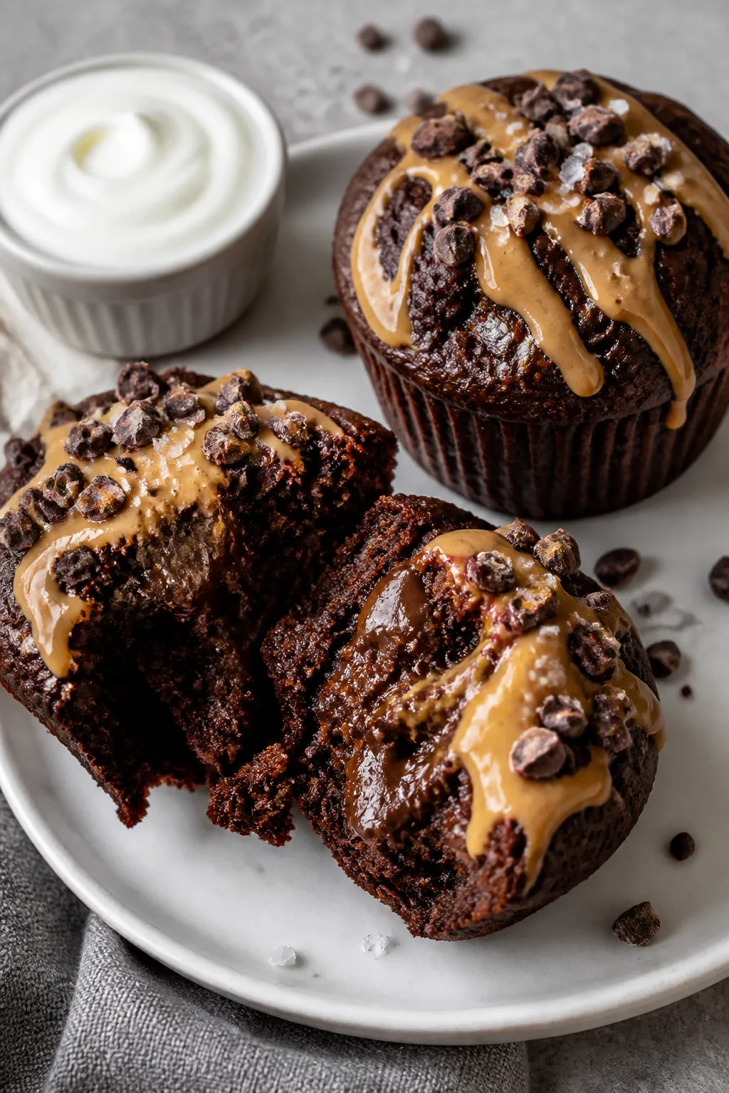 Close-up final presentation of two High Protein Chocolate Protein Muffins on a matte white plate, on