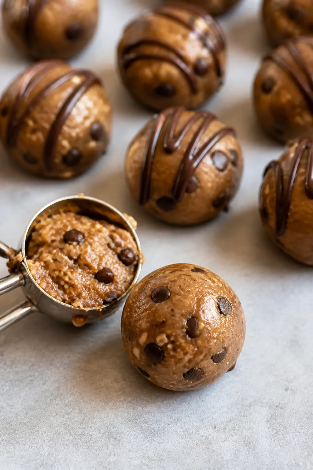 Close-up process shot of dough being rolled into uniform bites: a small cookie scoop portion transfo