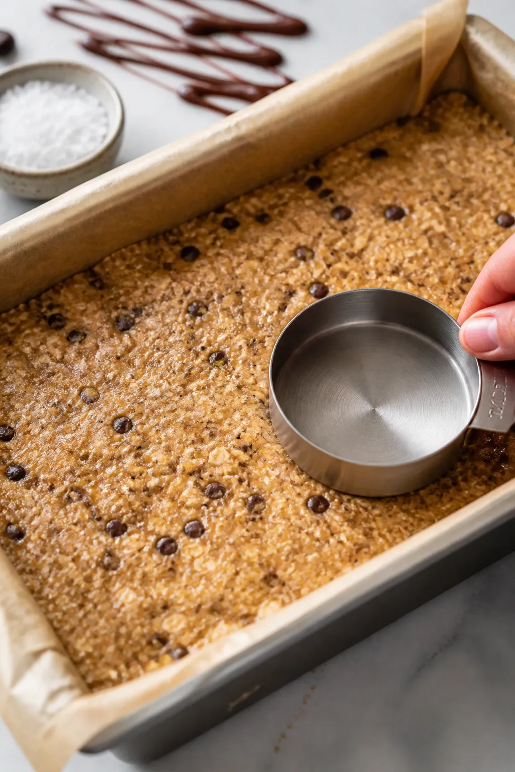 Close-up, three-quarter angle process shot of the pressed mixture in the lined pan just before chill