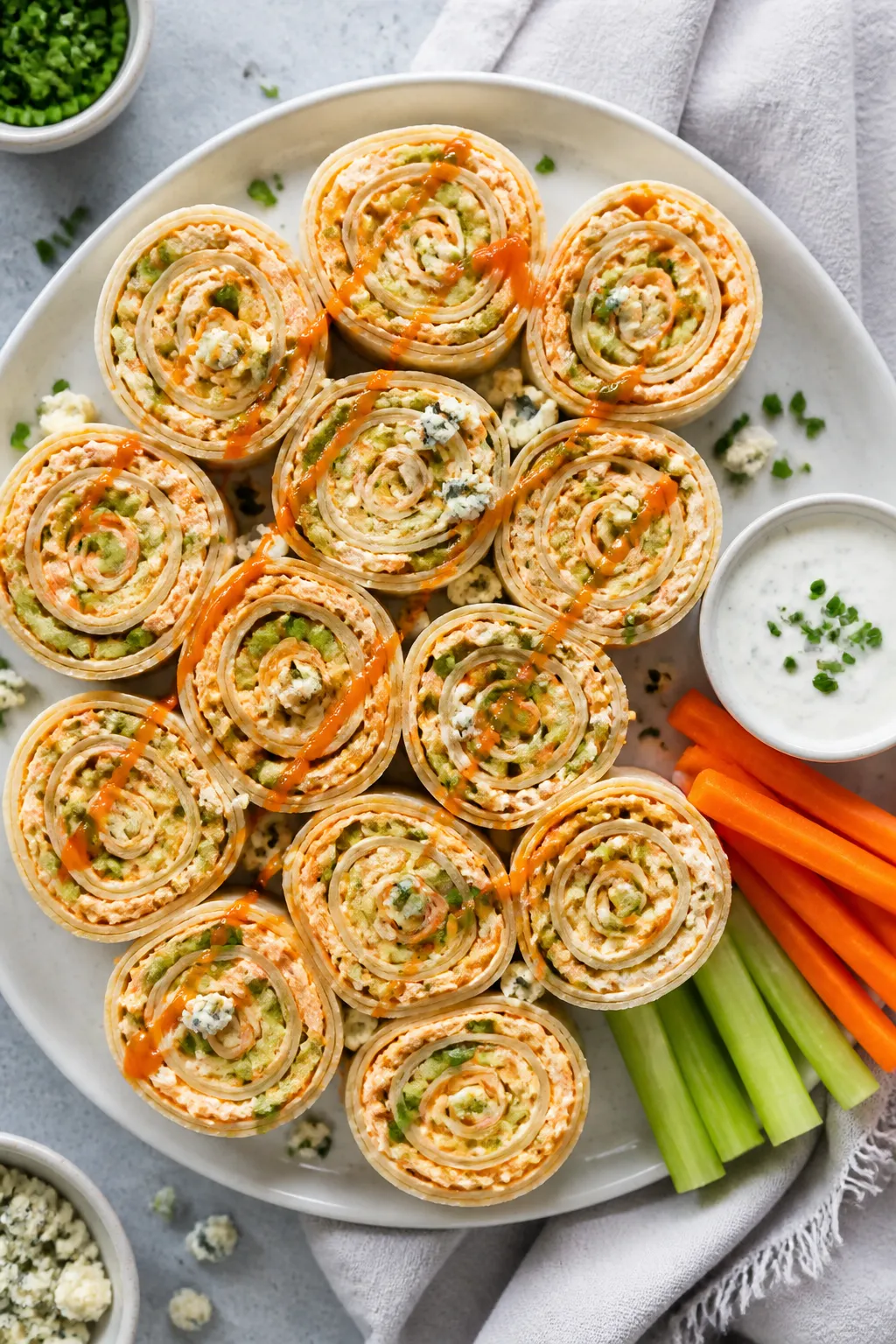 Final dish, tasty top view: Overhead shot of a platter of high-protein buffalo chicken pinwheels arr