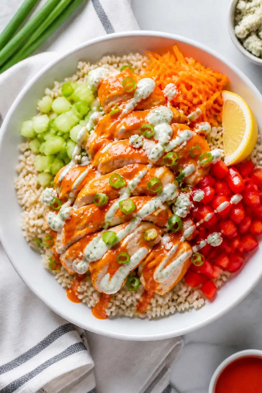 Final plated, overhead bowl: Overhead shot of a Low Fat Buffalo Chicken Rice Bowl in a wide, shallow