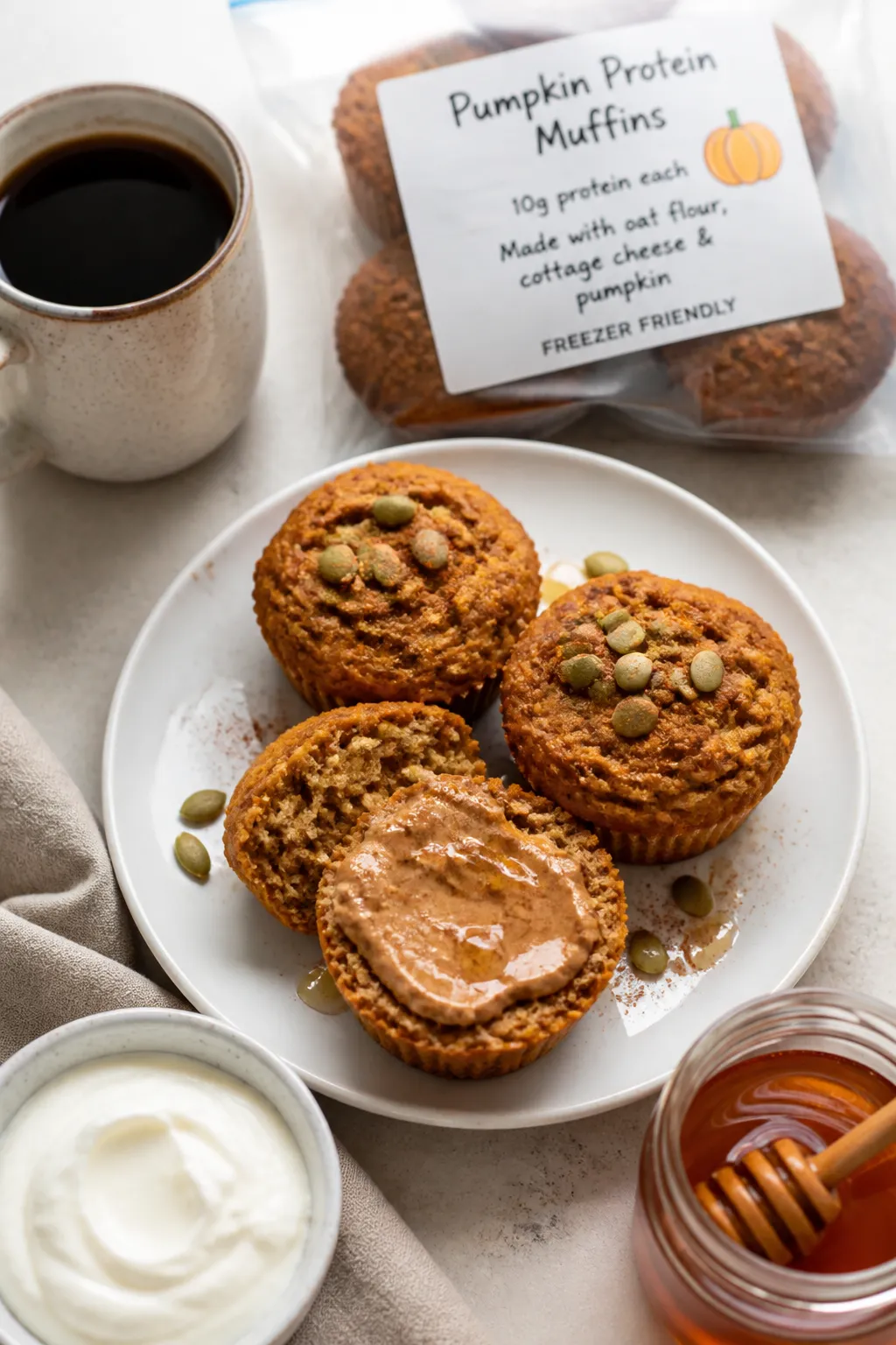 Final plated overhead: Tasty top-down shot of three pumpkin protein muffins on a matte white plate,