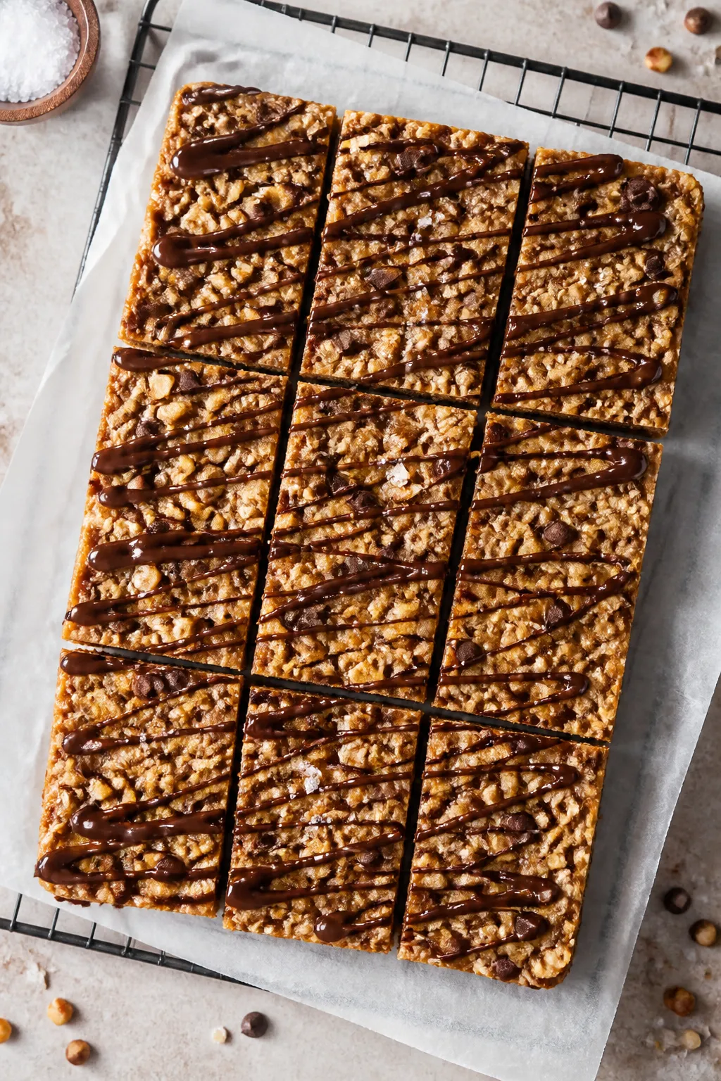 Overhead shot of a freshly sliced slab of no-bake peanut butter protein bars on parchment lifted fro
