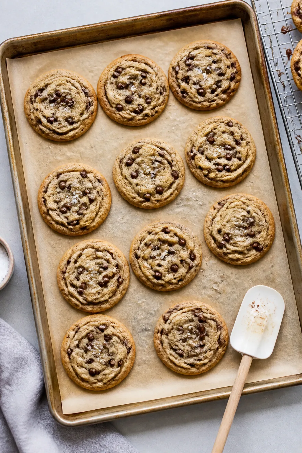 Overhead shot of freshly baked high-protein chocolate chip cookies resting on a parchment-lined shee
